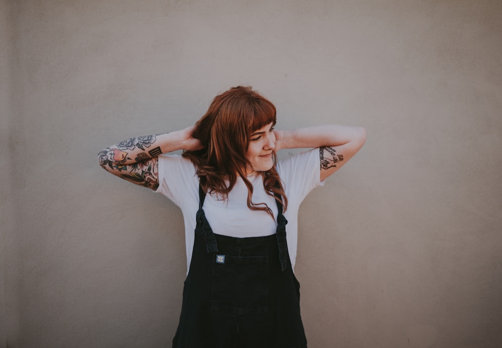 a woman with a tattoo on her arm and arms behind her head