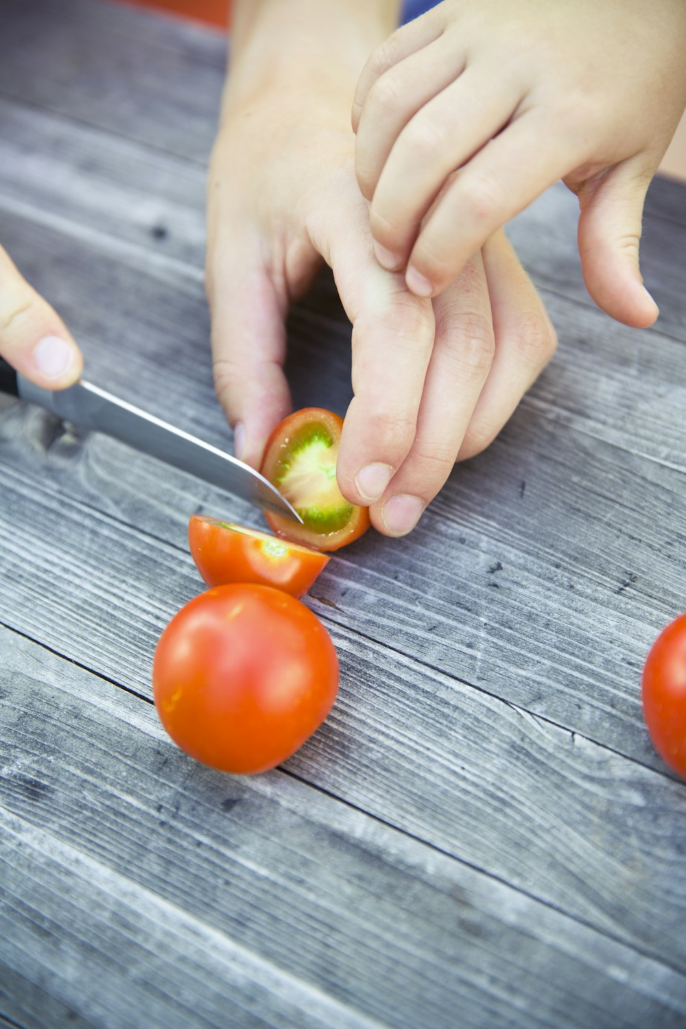 person slicing tomatoe