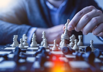 depth of field photography of man playing chess