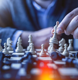 depth of field photography of man playing chess