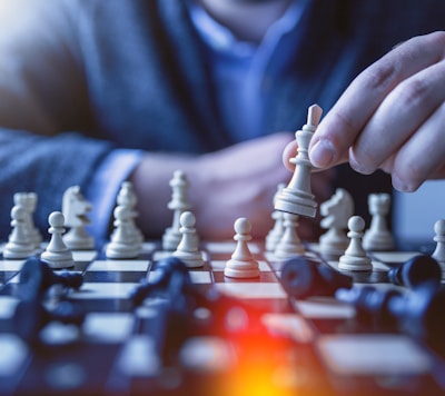 depth of field photography of man playing chess