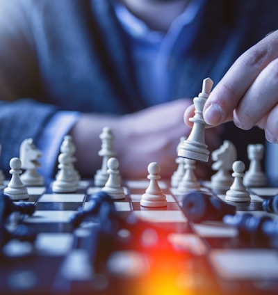 depth of field photography of man playing chess