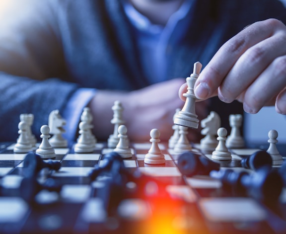 depth of field photography of man playing chess