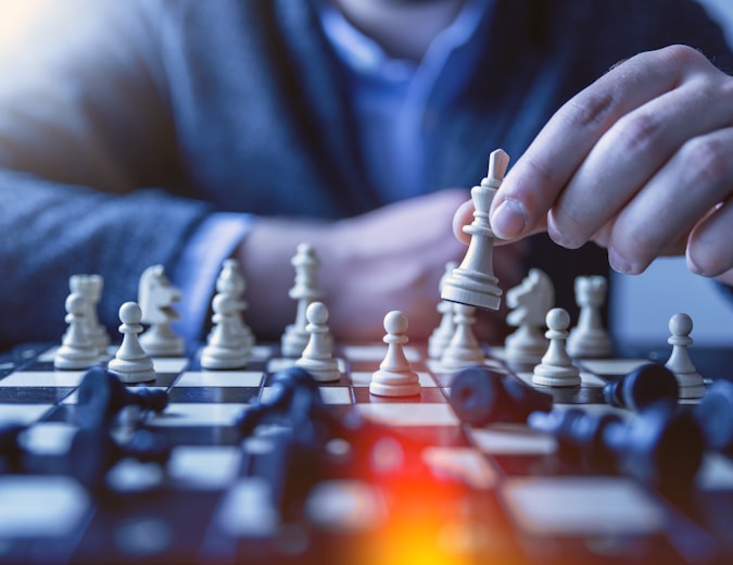 depth of field photography of man playing chess