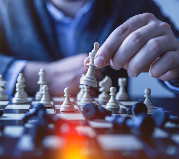 depth of field photography of man playing chess