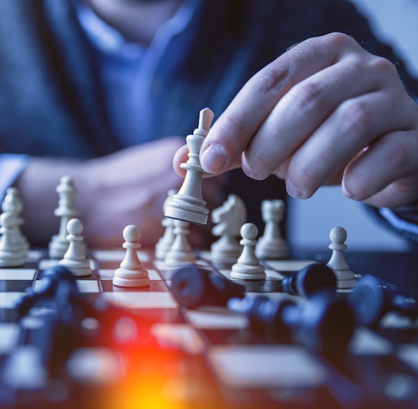 depth of field photography of man playing chess
