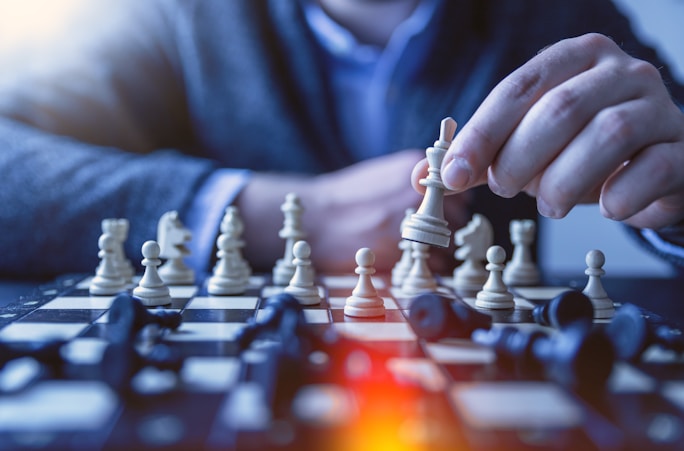 depth of field photography of man playing chess