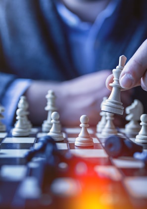 depth of field photography of man playing chess