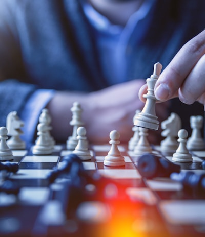 depth of field photography of man playing chess