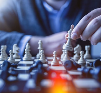 depth of field photography of man playing chess