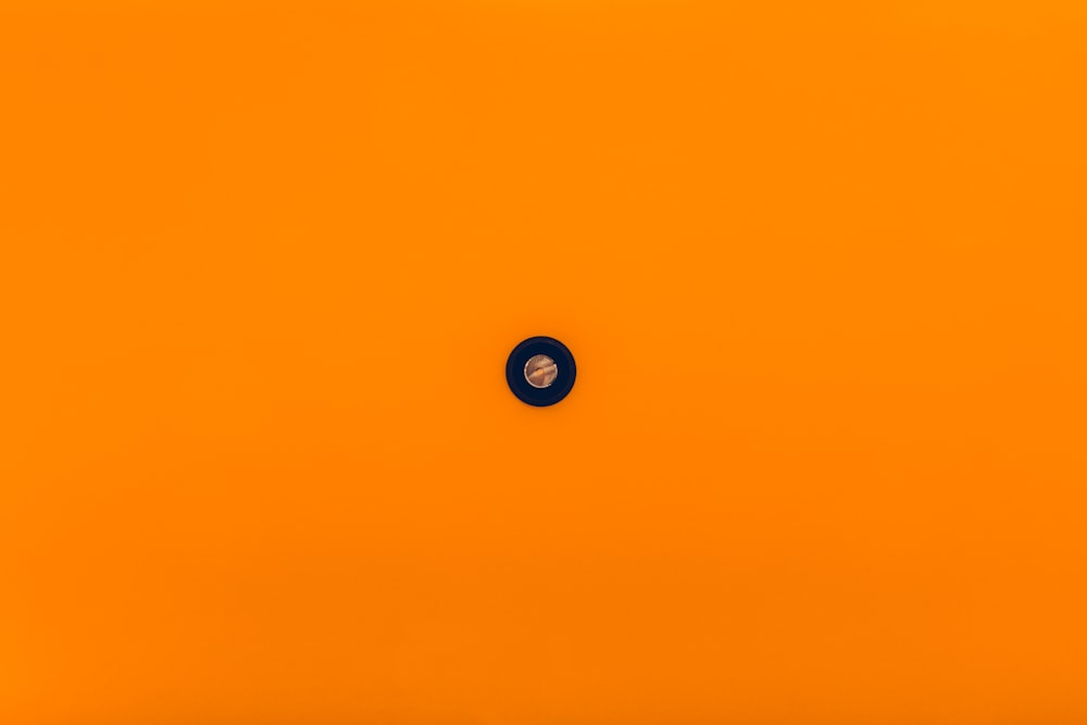 an orange background with a black circle in the center