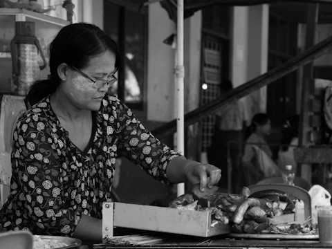 Close-up of a food stylist arranging a modern market food display with fresh ingredients.