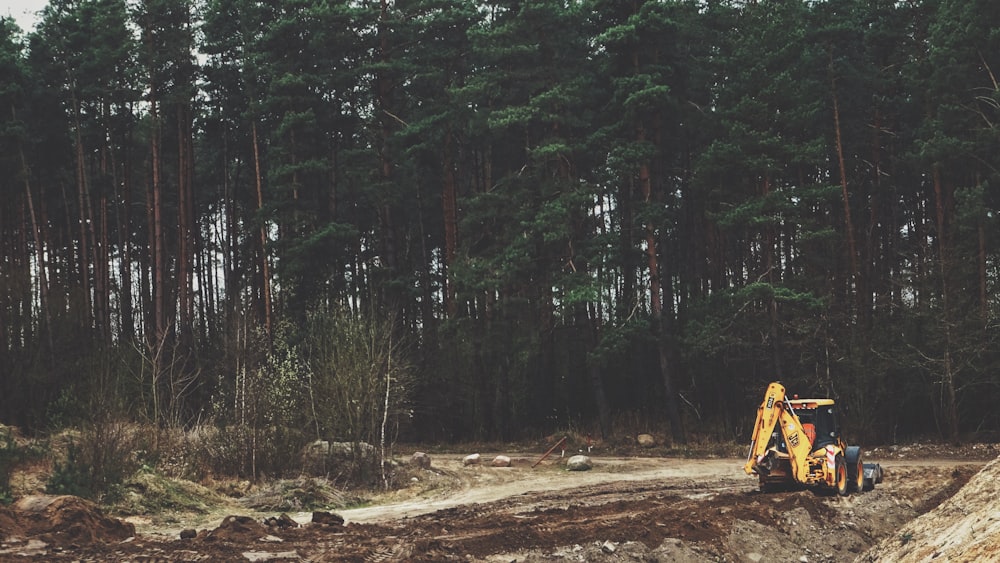 yellow front-loader near trees