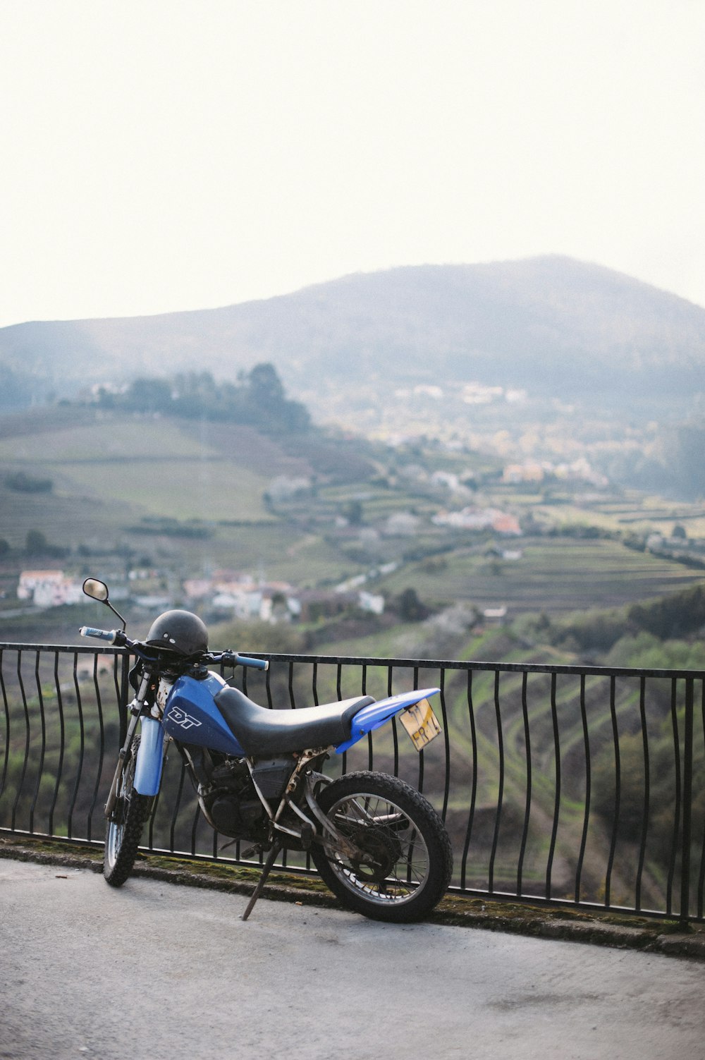 moto noire garée à côté d’une clôture en métal noir pendant la journée