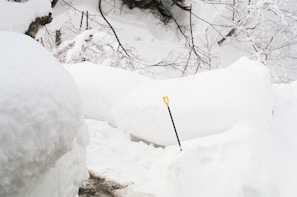 A snow-covered pathway being cleared with a shovel.