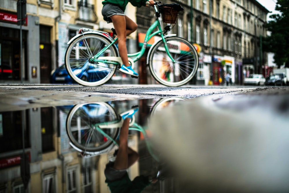 personne roulant sur un vélo hollandais turquoise