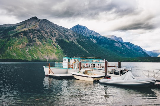 white motorboard docking on body of water in Glacier National Park United States