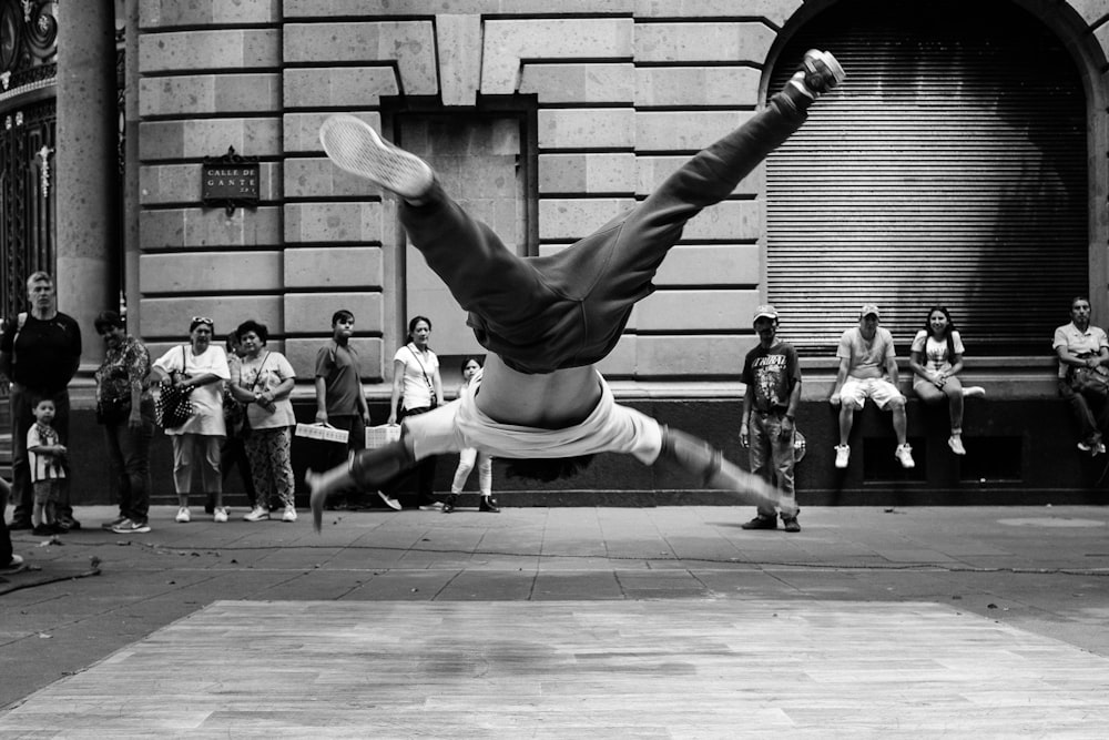 jumping man in grayscale photography