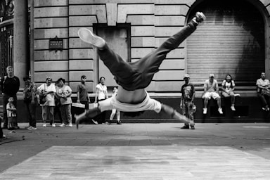 street photography,how to photograph a photograph of a break dancer in mexico city; jumping man in grayscale photography