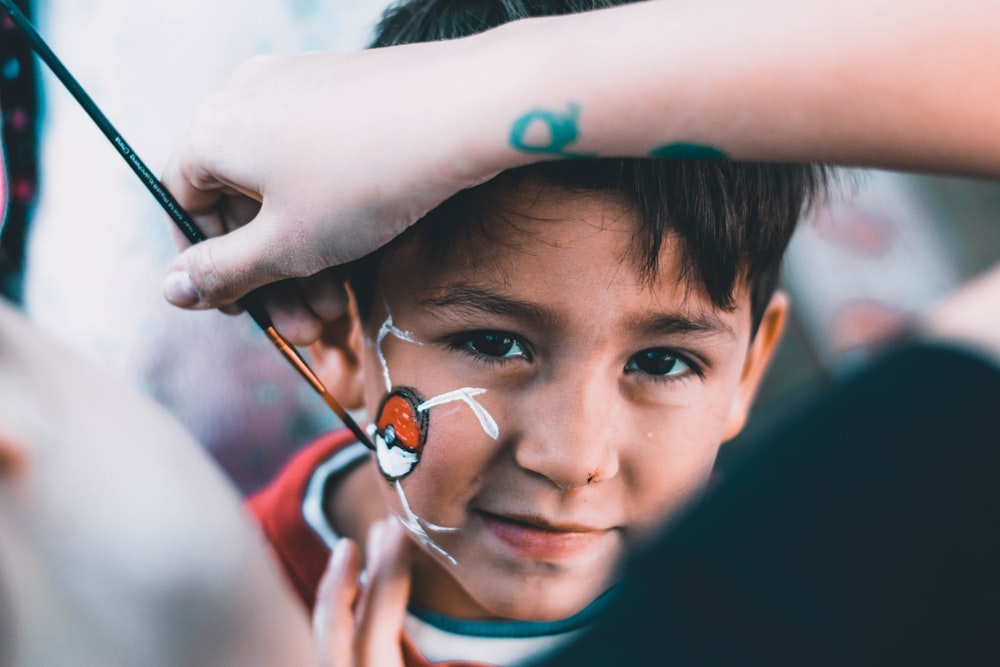 boy drawn Pokeball on his face