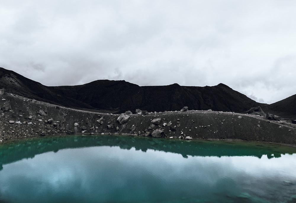 lac entouré de montagnes sous un ciel nuageux