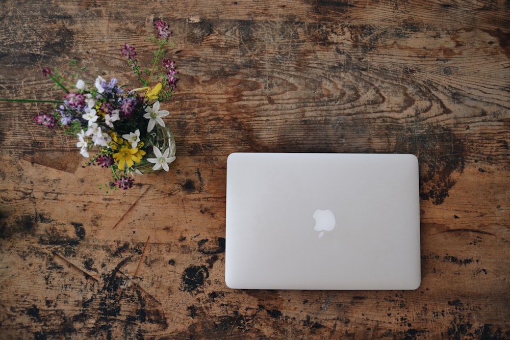 MacBook blanc sur une surface en bois marron