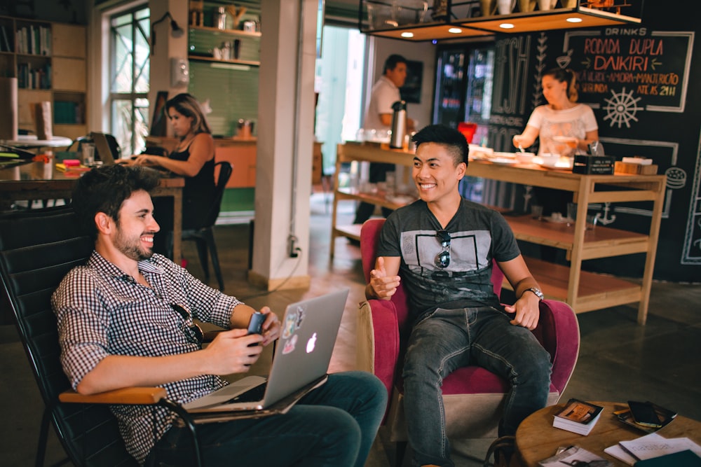 two men laughing white sitting on chairs