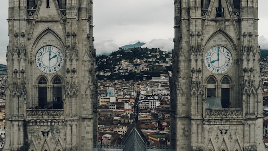 close-up photography of gray concrete clock towers in Basilica del Voto Nacional Ecuador