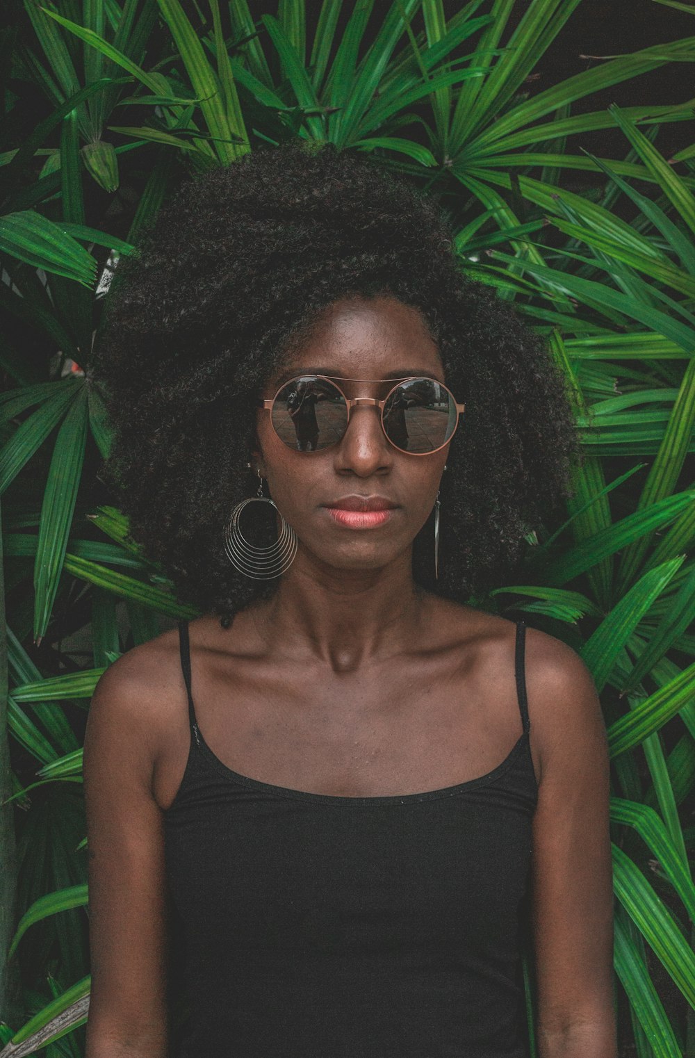 Mujer de pie frente a la planta verde