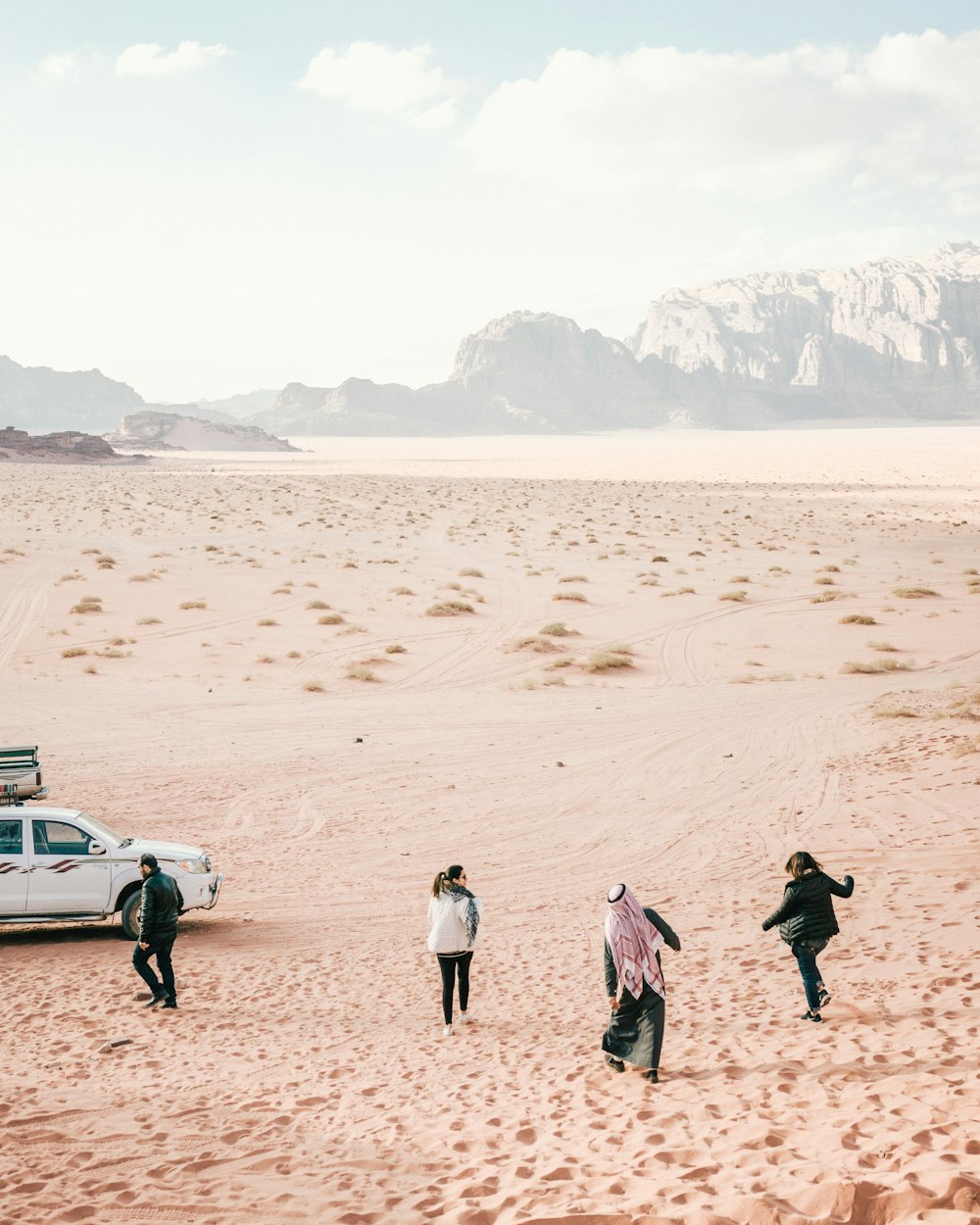 four person standing on desert