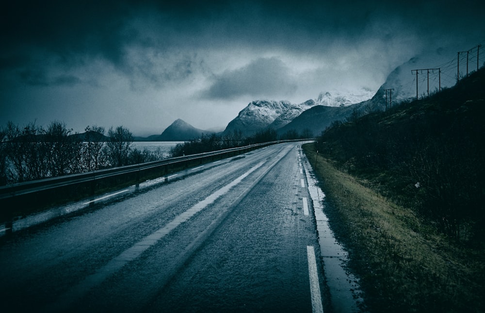 Fotografia de estrada vazia perto de montanhas glaciares durante o dia