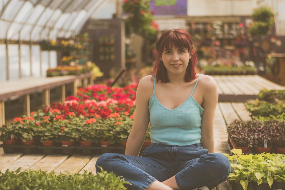 woman sitting inside green house beside plants