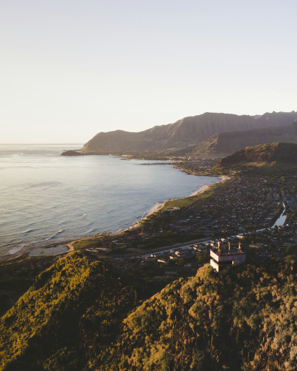 houses near body of water and mountain at distance