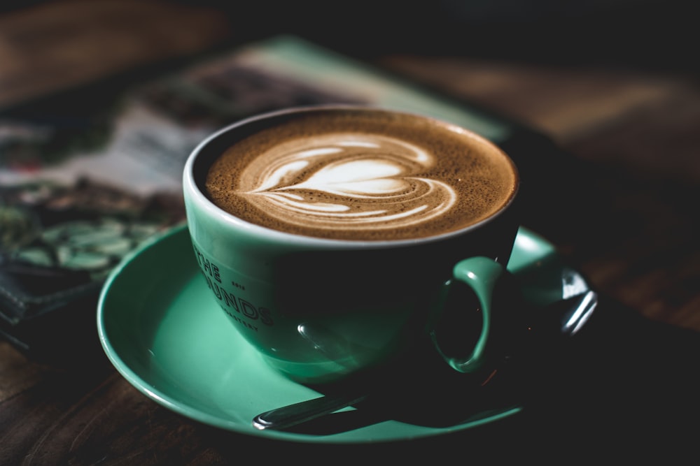 taza de té de cerámica verde llena de café con leche