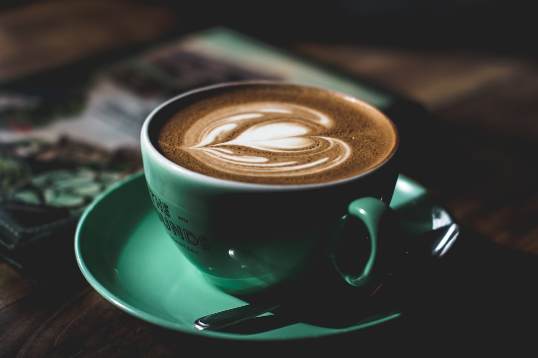 green ceramic teacup filled with latte, Coffee