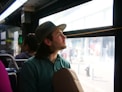 man staring outside of bus window