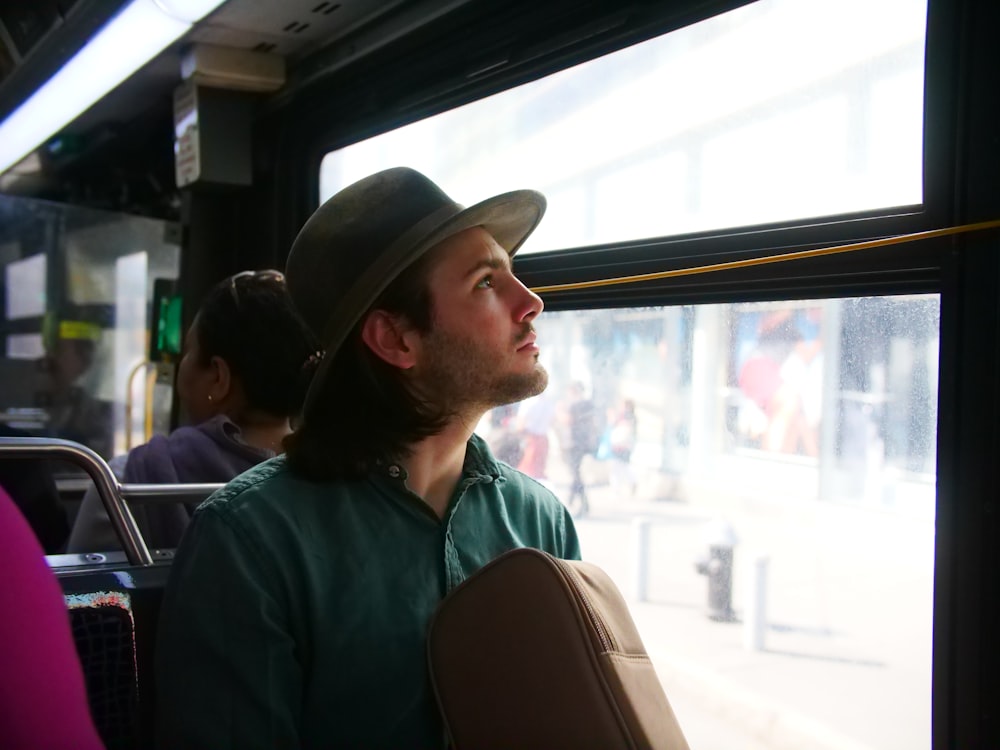 man staring outside of bus window