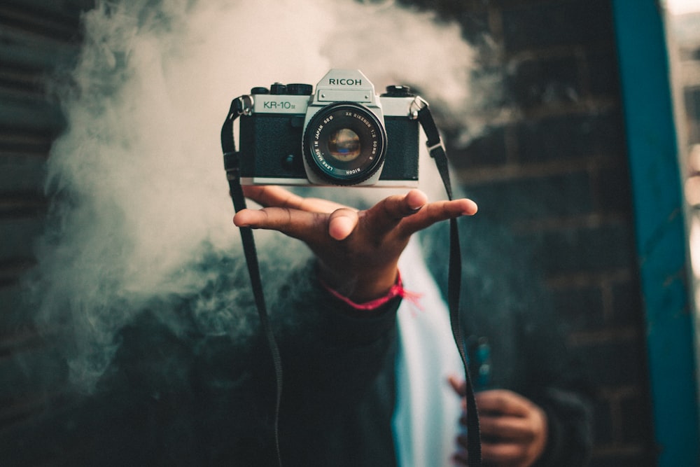 Person catching Ricoh DSLR camera photo – Free Person Image on Unsplash