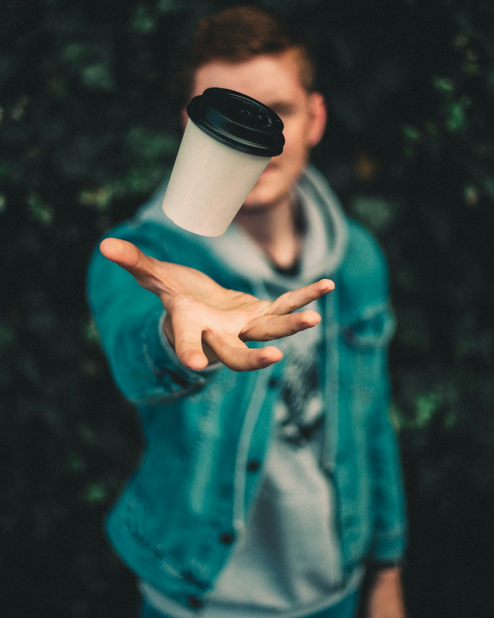 person throwing disposable cup