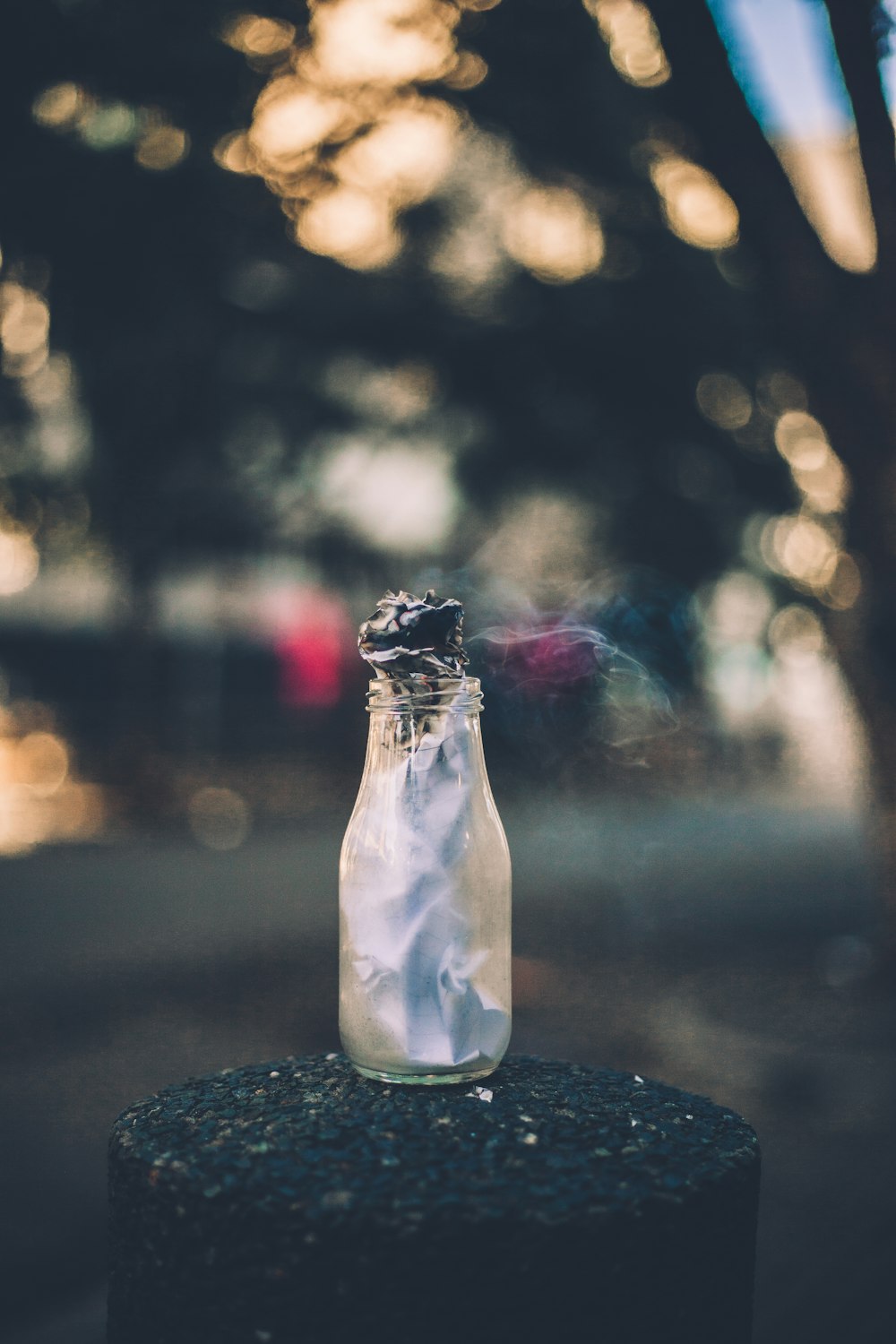 clear glass bottle on black post at nighyt