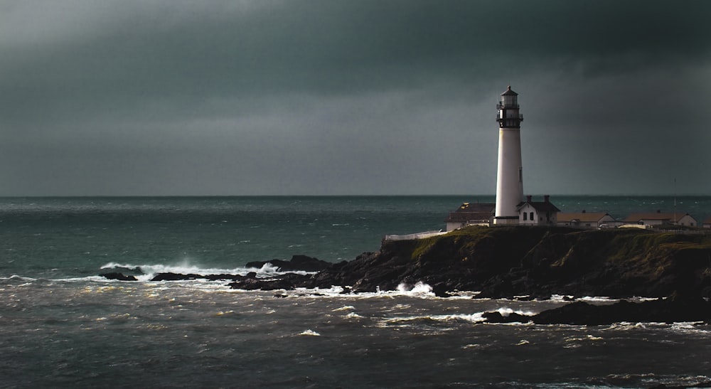 white lighthouse beside shore