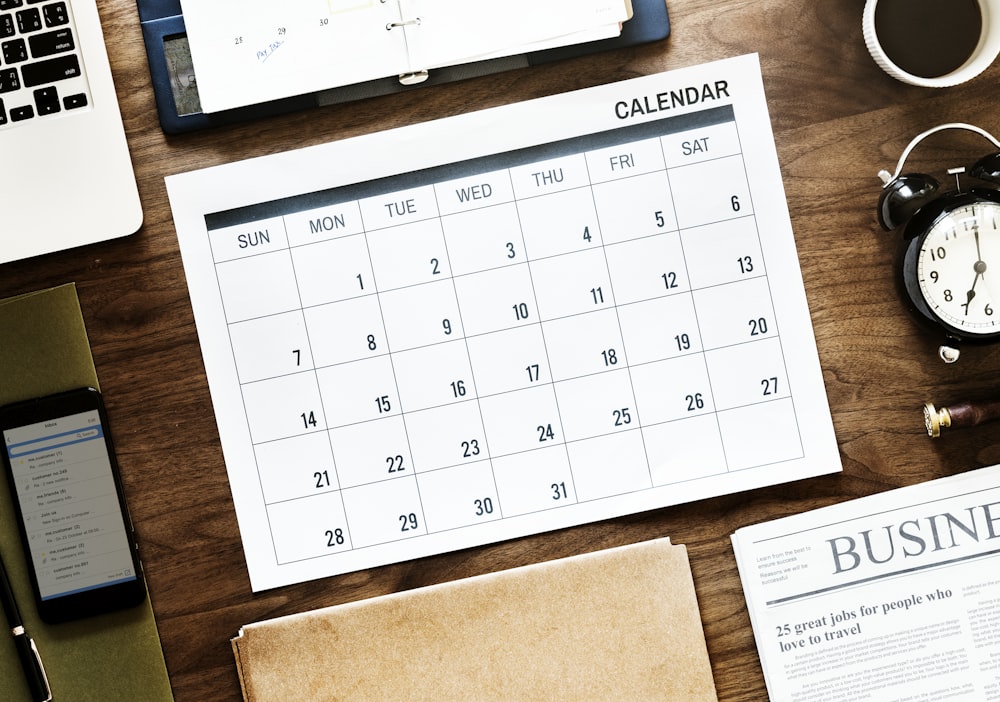 31-days calendar near round white analog alarm clock