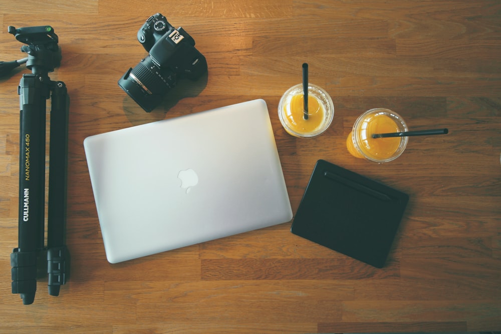 MacBook gris à côté de l’appareil photo reflex numérique
