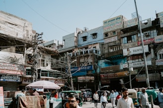 people walking on street in front of building under blue sky