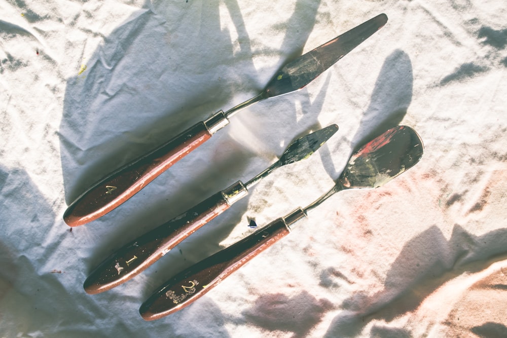 black and red handled knives on white textile