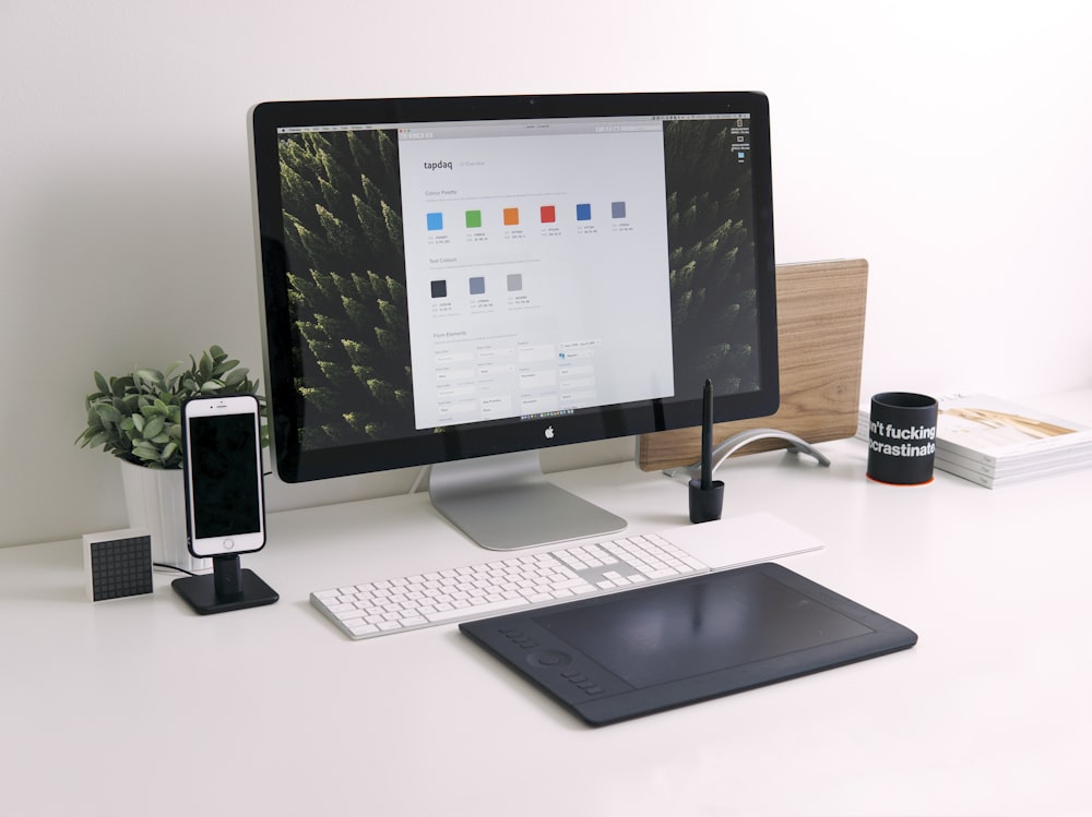 흰색 책상 위의 Thunder iMac, 키보드 및 트랙패드의 근접 촬영 사진