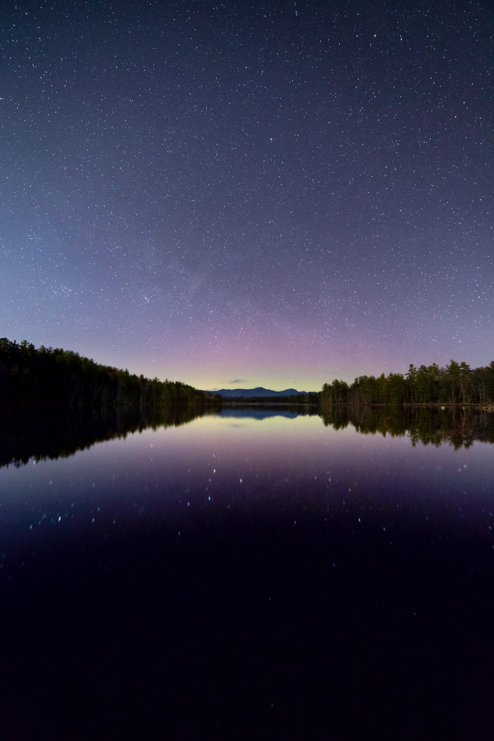 fotografia di riflessione della stella e del cielo sotto lo specchio d'acqua calmo