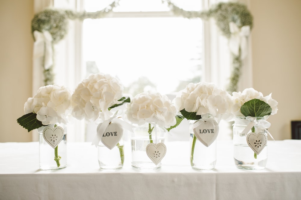 white flowers in glass jars