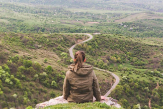 woman sitting on grey cliff