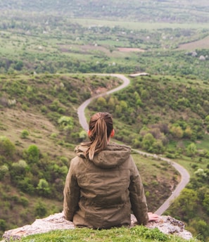 woman sitting on grey cliff